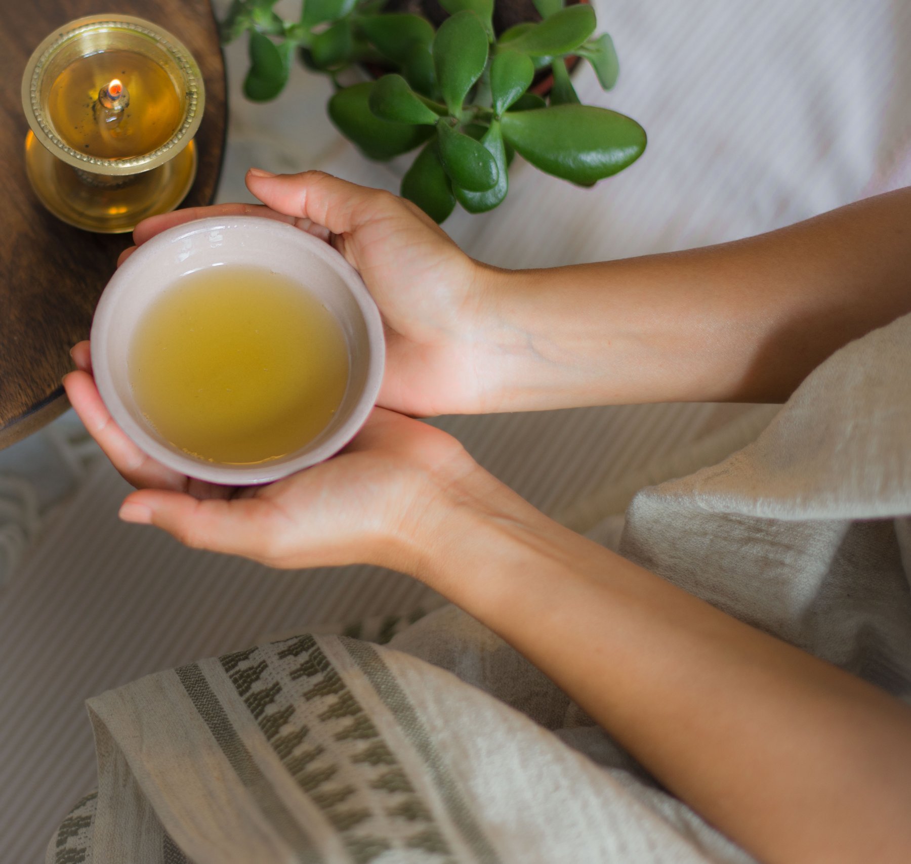 Warm oil being poured for an Abhyanga self-massage